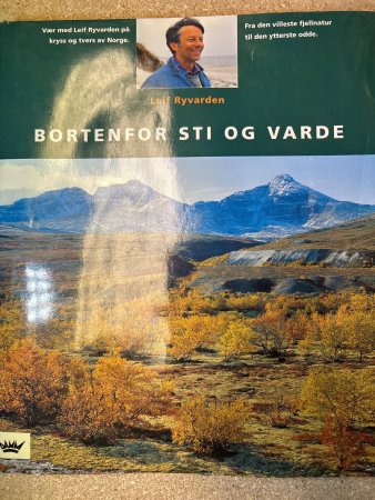Bortenfor sti og varde innbundet bok av Cappelen Damm AS med tittel på forsiden, vises foran.
