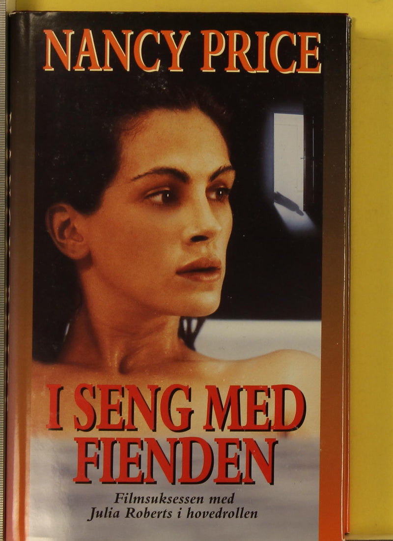 Bokomslag for "I seng med fienden", spenningskrim innbundet utgave fra Cappelen Damm AS, viser en mørk, dramatisk scene.