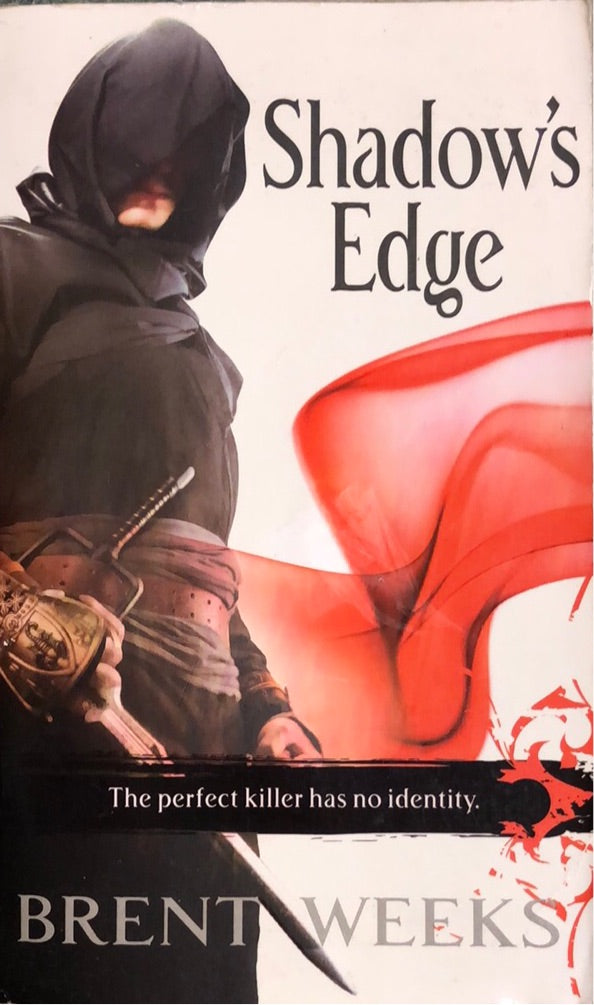 Bok "Shadow's Edge" fra Bokia.no, pocketutgave med omslag og tittel visible i bildet