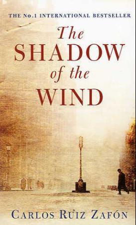 Bokcover for "The Shadow of the Wind" av Vigmostad & Bjørke AS, pocketutgave, med skygge og bybakgrunn.